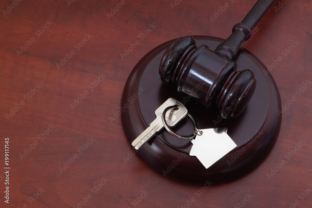 Judge gavel and keys with key holder on table with copyspace Judge gavel and keys with key holder on table with copyspace