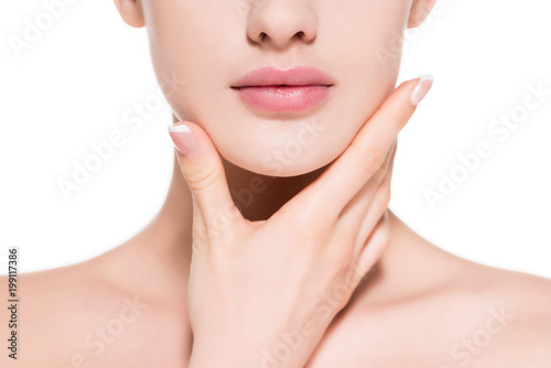 cropped shot of young woman touching her chin isolated on white photo