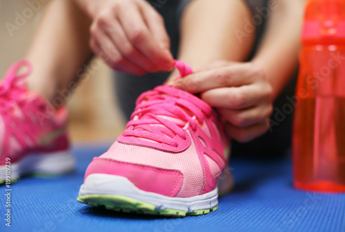 Woman tying the shoelaces of her fitness shoes.