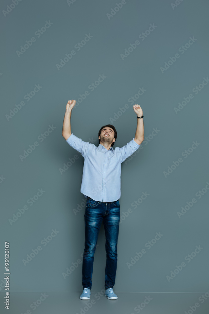 Overwhelmed by emotions. Positive nice joyful man smiling and looking up while being overwhelmed by emotions Overwhelmed by emotions. Positive nice joyful man smiling and looking up while being overwhelmed by emotions