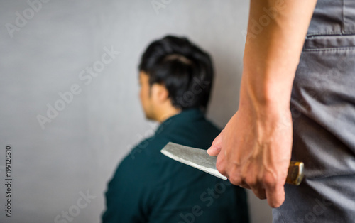 Knife hand hold with man sitting, backstabbing photo
