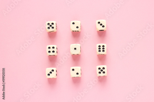 Gaming dice organized in rows on pink background in flat style. Concept for banners, web, games, web, presentation. Top view.