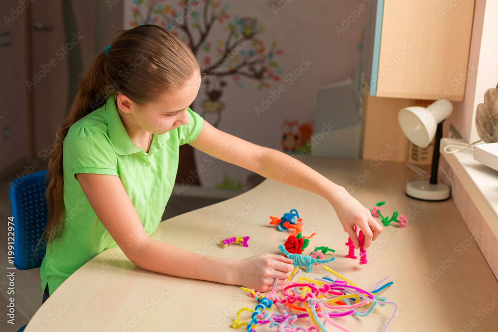 Cute little girl creating toys with chenille sticks Cute little girl creating toys with chenille sticks