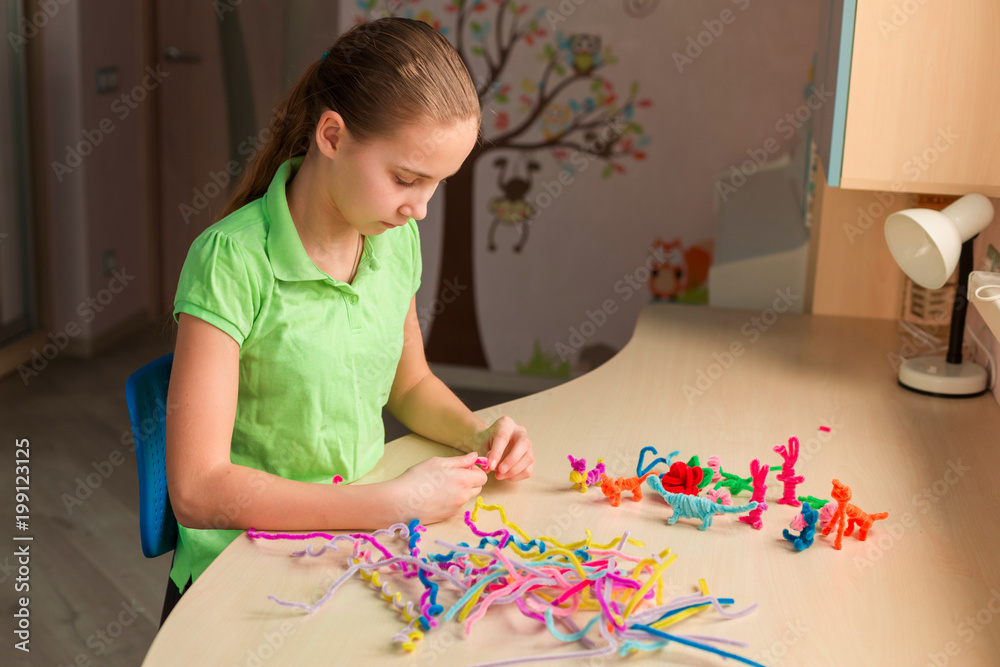 Cute little girl creating toys with chenille sticks Cute little girl creating toys with chenille sticks