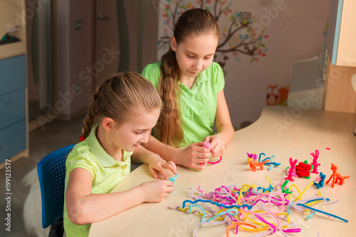 Cute little girls creating toys with chenille sticks photo
