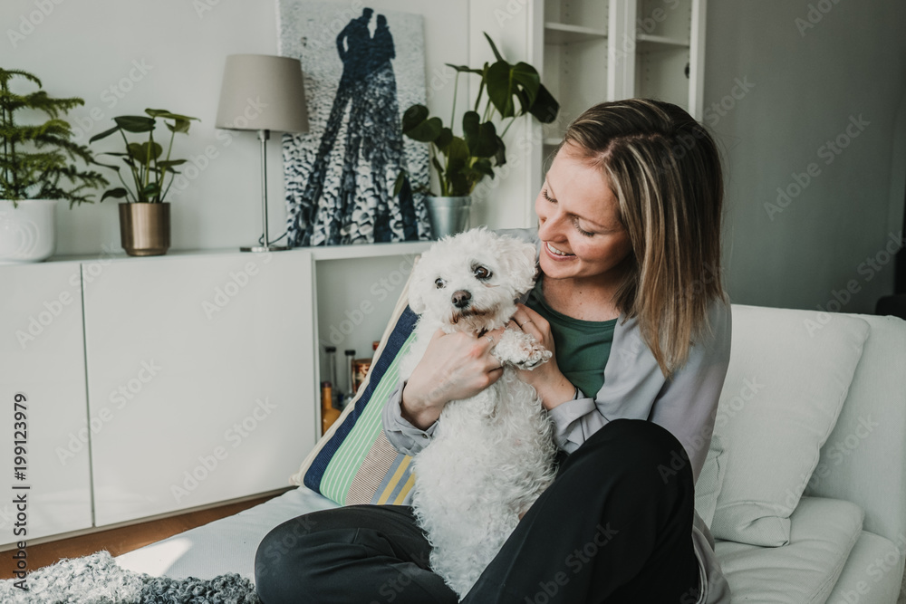 Young and beautiful sweedish blonde girl playing with her cute little french bichon dog at home. Sweet relation. Lifestyle photography Young and beautiful sweedish blonde girl playing with her cute little french bichon dog at home. Sweet relation. Lifestyle photography