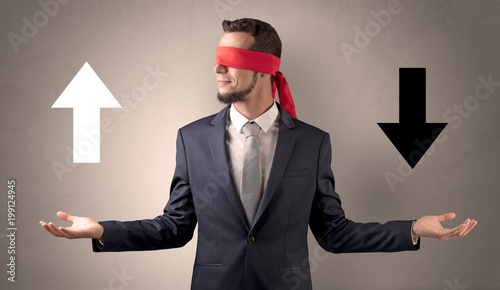Covered eye businessman choosing between two directions 