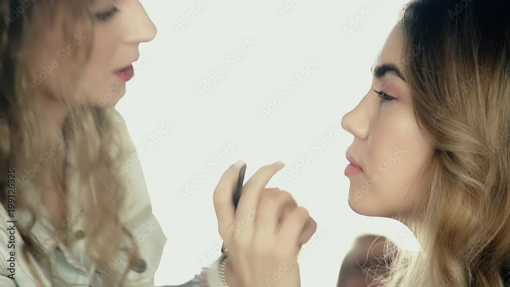 Makeup artist applies makeup, model is young beauty girl, making lips, close up Makeup artist applies makeup, model is young beauty girl, making lips, close up
