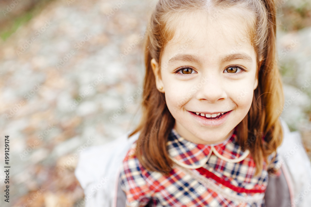 Little girl looking at the camera in the countryside in fall season Little girl looking at the camera in the countryside in fall season
