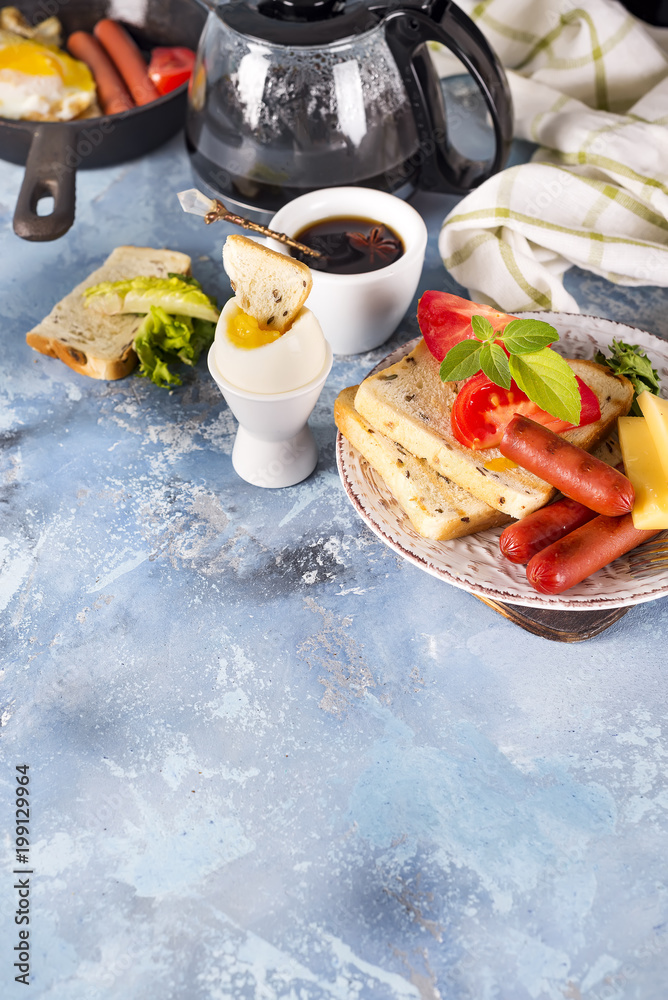English breakfast. Fried eggs, sausages, toasts, tomatoes on stone table. English breakfast. Fried eggs, sausages, toasts, tomatoes on stone table.