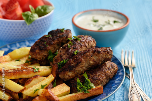 Cevapcici, balkanian grilled meat sausages with fries and yogurt dip.