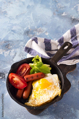 Homemade delicious breakfast on a pan with fried egg, toast, sausage, vegetable, black coffee photo