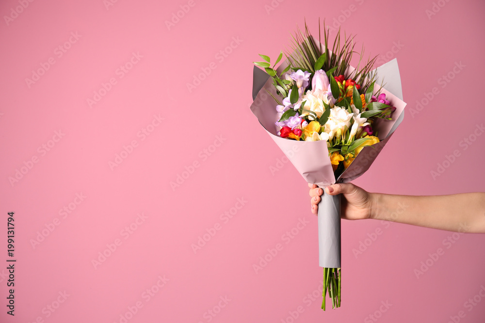 Fototapeta premium Kobieta z pięknym bukietem frezja kwitnie na koloru tle