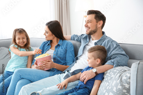 Family watching TV on sofa ...