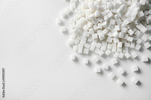 Refined sugar cubes on light background, top view