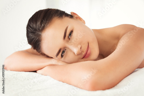 Young woman lying on massage table in spa salon