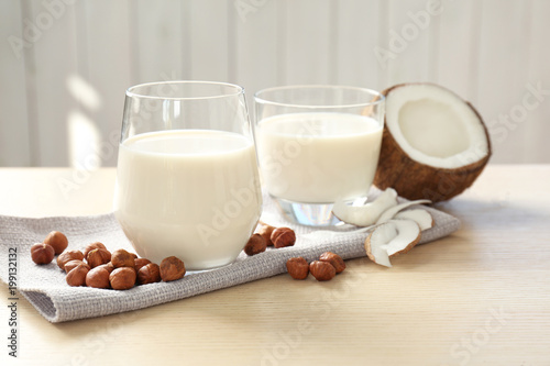 Glasses with milk substitute and nuts on kitchen table