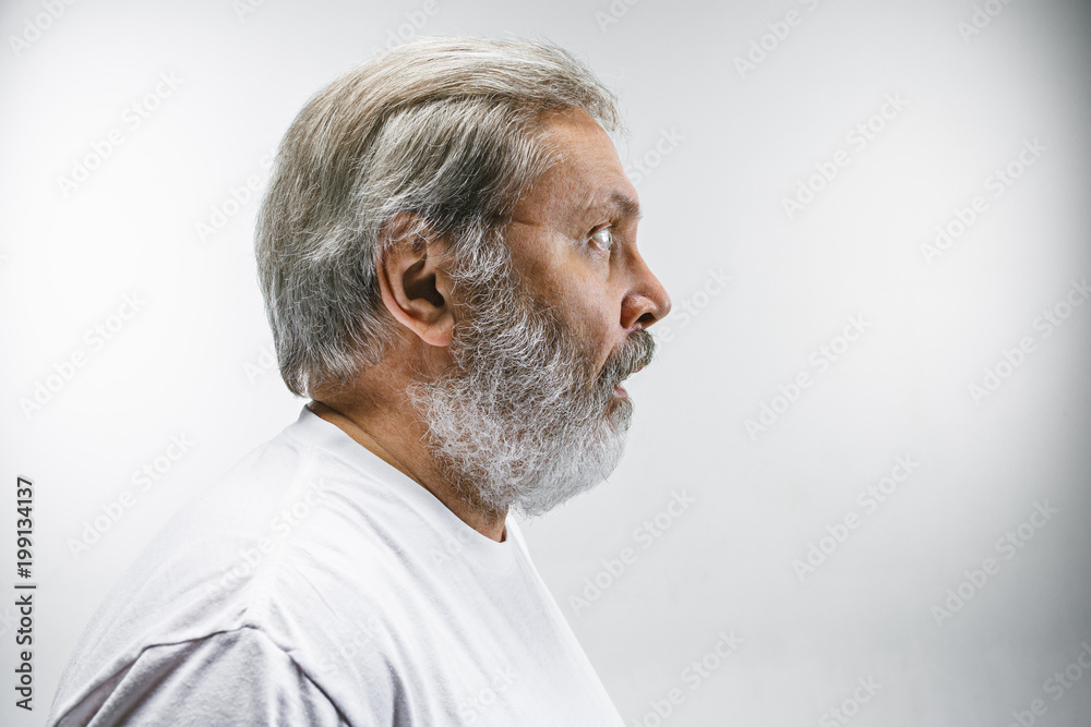 The senior attractive man looking suprised isolated on white The senior attractive man looking suprised isolated on white
