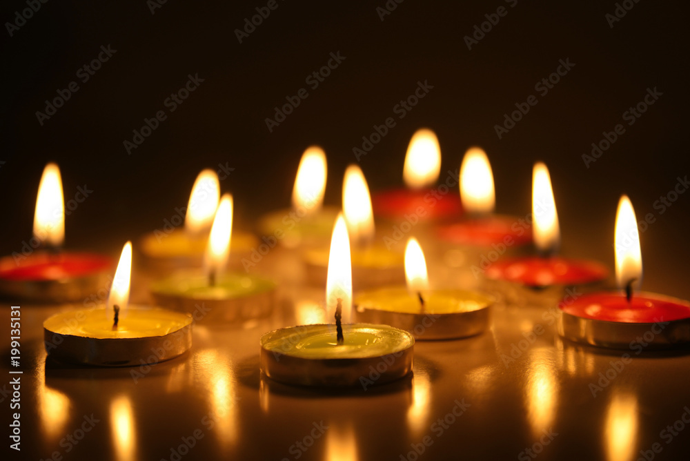 Multicolored lighted candles in the dark