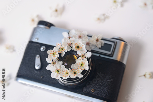 Old retro camera with spring small flowers, close-up