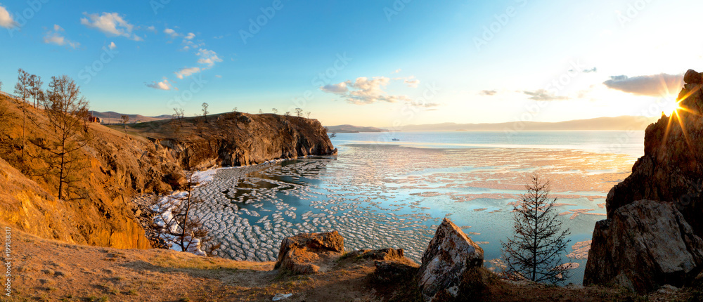 Lake Baikal in the May ice drift. Panoramic view of the coastal cliffs of the island of Olkhon near the village of Khuzhir in the sunset