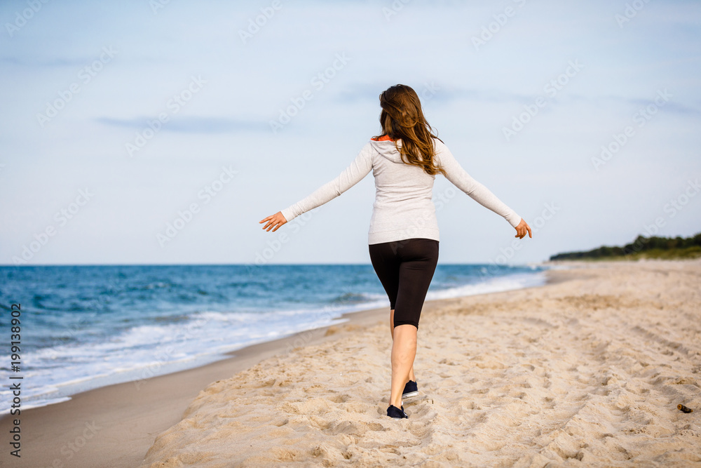 Young woman walking on beach