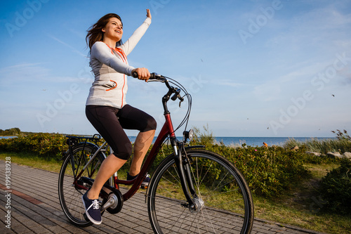 Young woman riding bike at seaside