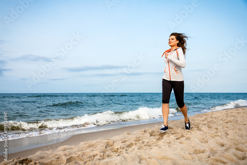 Young woman running, jumping on beach © Jacek Chabraszewski