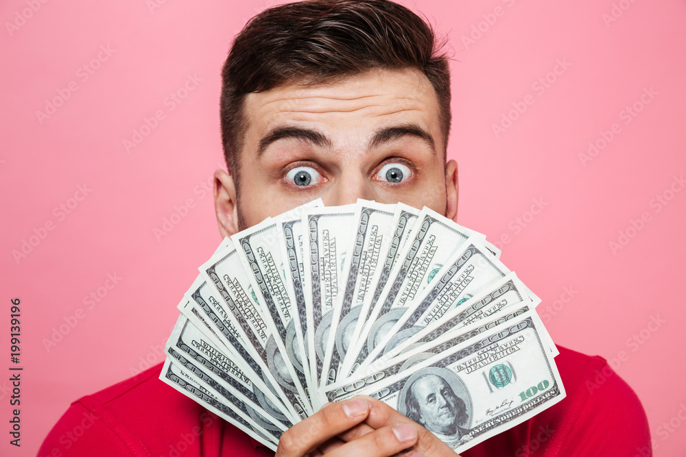 Portrait of a cheerful young man holding money banknotes Portrait of a cheerful young man holding money banknotes