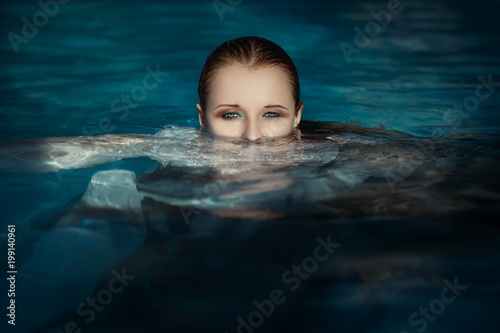 Beautiful model is posing in a swimming pool