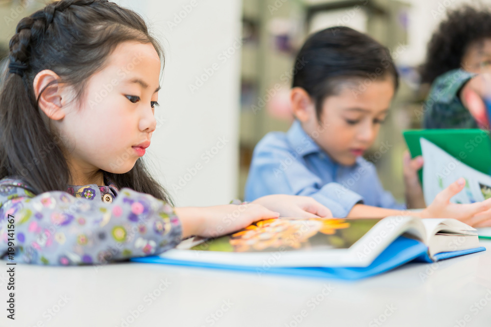Kids girl and boy reading book at library in school. concept of education learning. Kids girl and boy reading book at library in school. concept of education learning.
