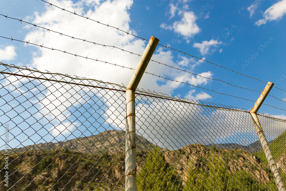 Fence with barbed wire in the open air