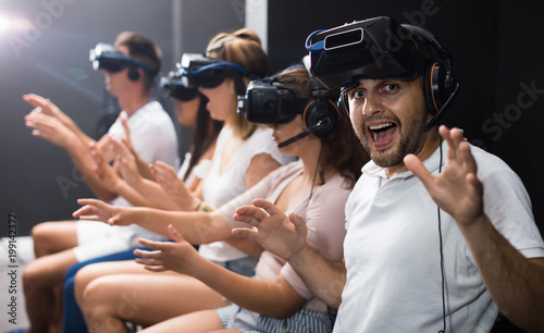Excited man experiencing with friends virtual reality