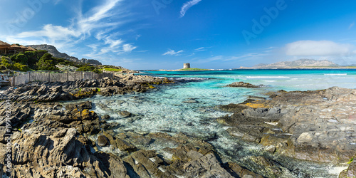Sardinia la pelosa stintino panorama view from the beach coast on ancient tower turquise blue sea ocean blue sky background