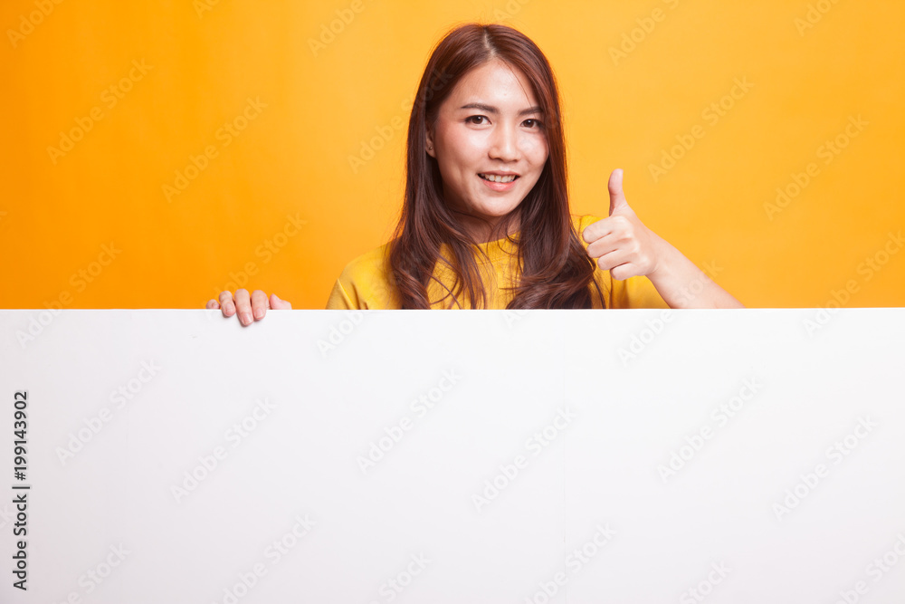 Young Asian woman show thumbs up with blank sign in yellow dress Young Asian woman show thumbs up with blank sign in yellow dress