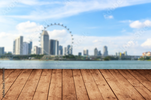 Wooden floor with blurred of cityscape skyline and beauty sky in background use for backdrop or design element in tropical summer concept.