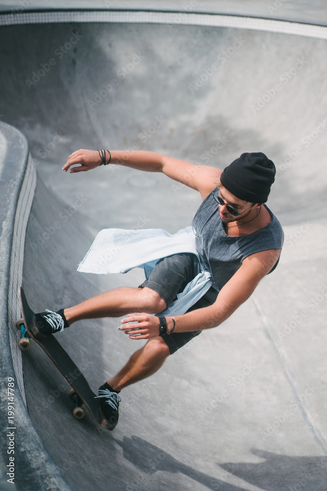 high angle view of young skater skating on longboard at skatepark high angle view of young skater skating on longboard at skatepark