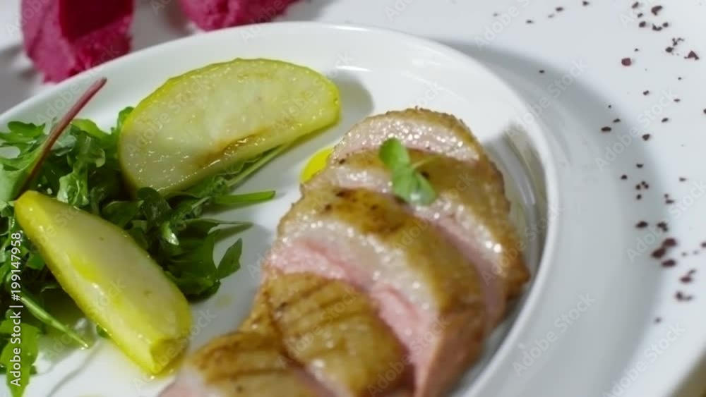 Close up of spinning plate with fried duck breast, sauteed apples and potato and beetroot mash Close up of spinning plate with fried duck breast, sauteed apples and potato and beetroot mash