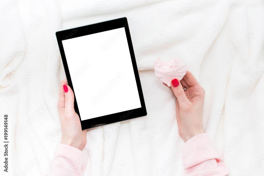 girl uses tablet pc, women's hands, red manicure, lying on the blanket, white background with copy space, for advertising, top view