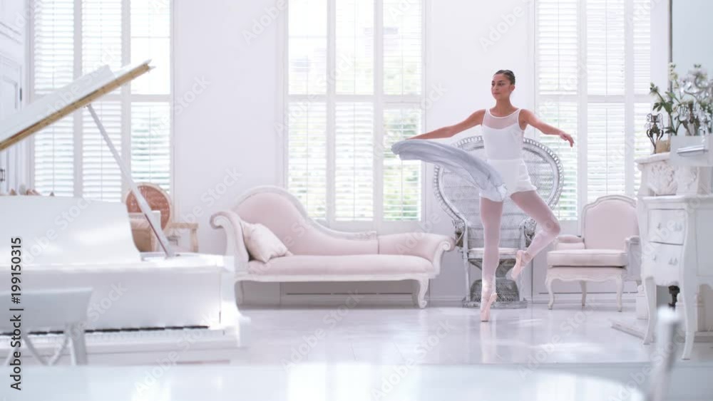 Graceful ballerina practicing ballet in white studio, slow motion Graceful ballerina practicing ballet in white studio, slow motion