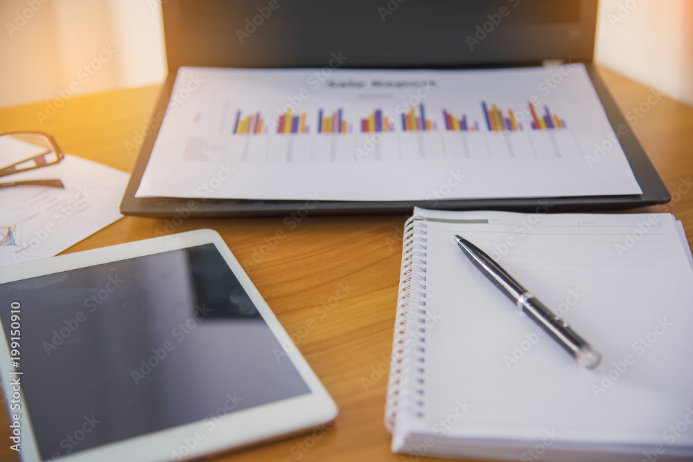 Laptop with financial documents on wooden table Laptop with financial documents on wooden table