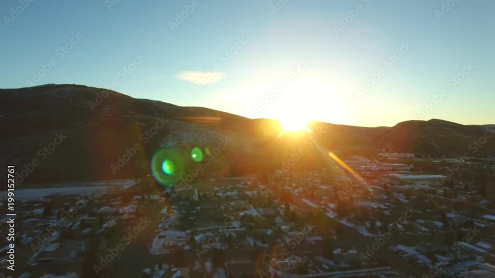 Morning Sun Flares Over a Small Town in Winter.