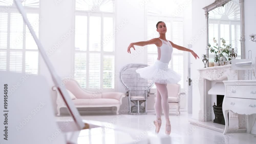 Graceful ballerina practicing ballet in white studio, slow motion Graceful ballerina practicing ballet in white studio, slow motion