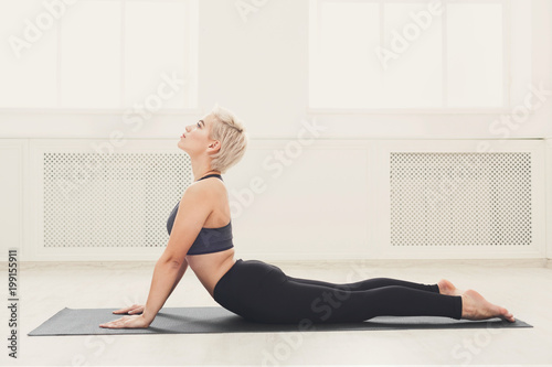 Woman training yoga in cobra pose.