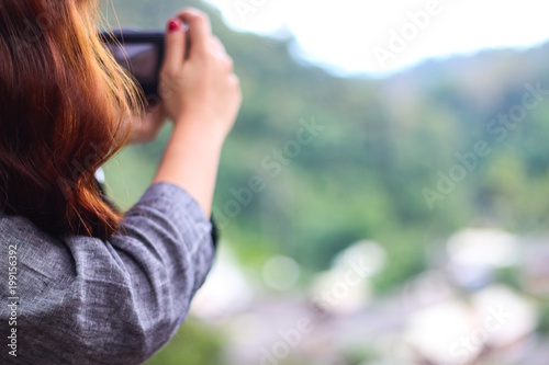 blur photographer , landscape mountain nature scene . woman long hair holding a camera in holiday at forest . relax traveler background .