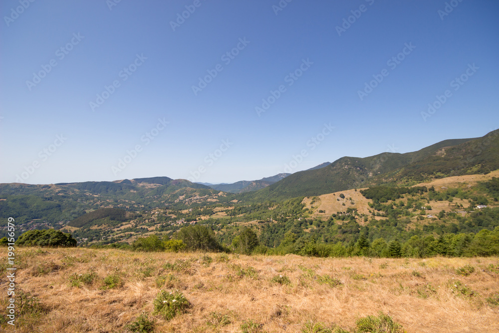 View of mountain landscape with sunny day in summertime and blue sky background, Summer mountains with dry grass and blue sky landscape.