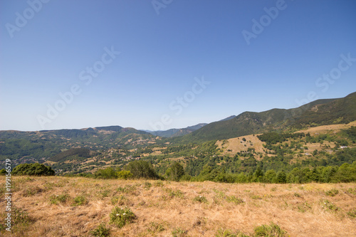 View of mountain landscape with sunny day in summertime and blue sky background, Summer mountains with dry grass and blue sky landscape.