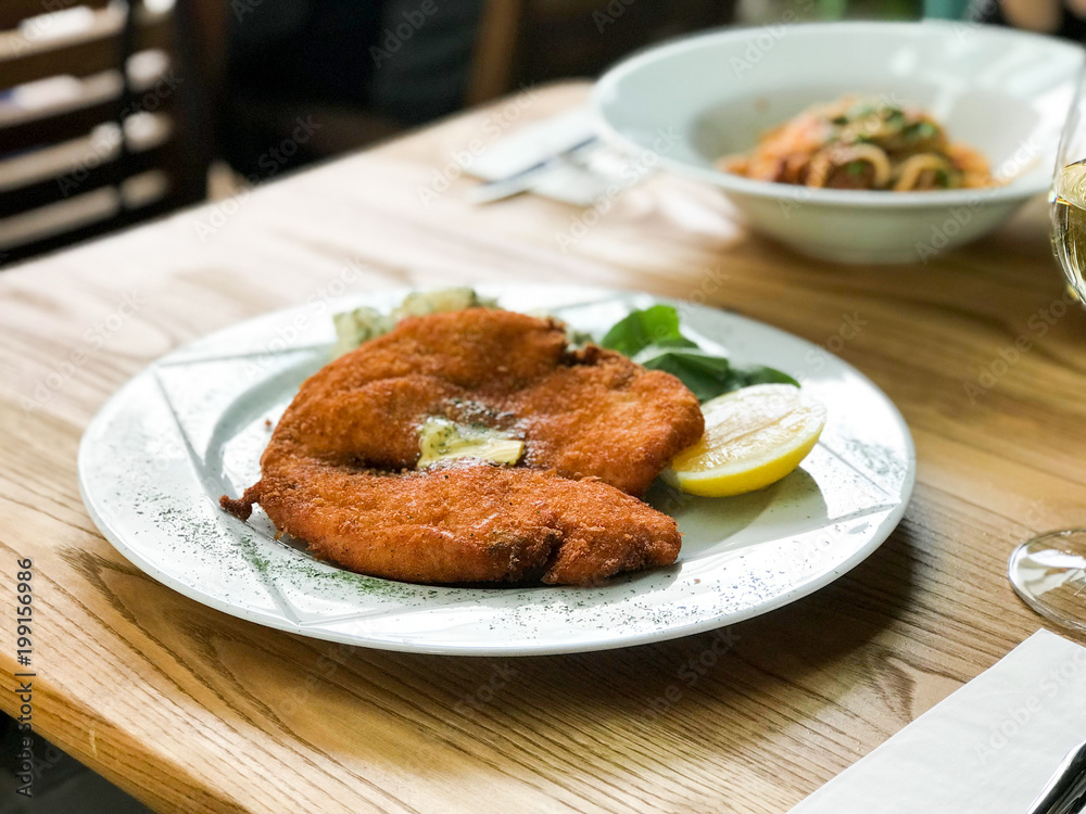 Chicken Schnitzel with potato salad and lemon served at restaurant