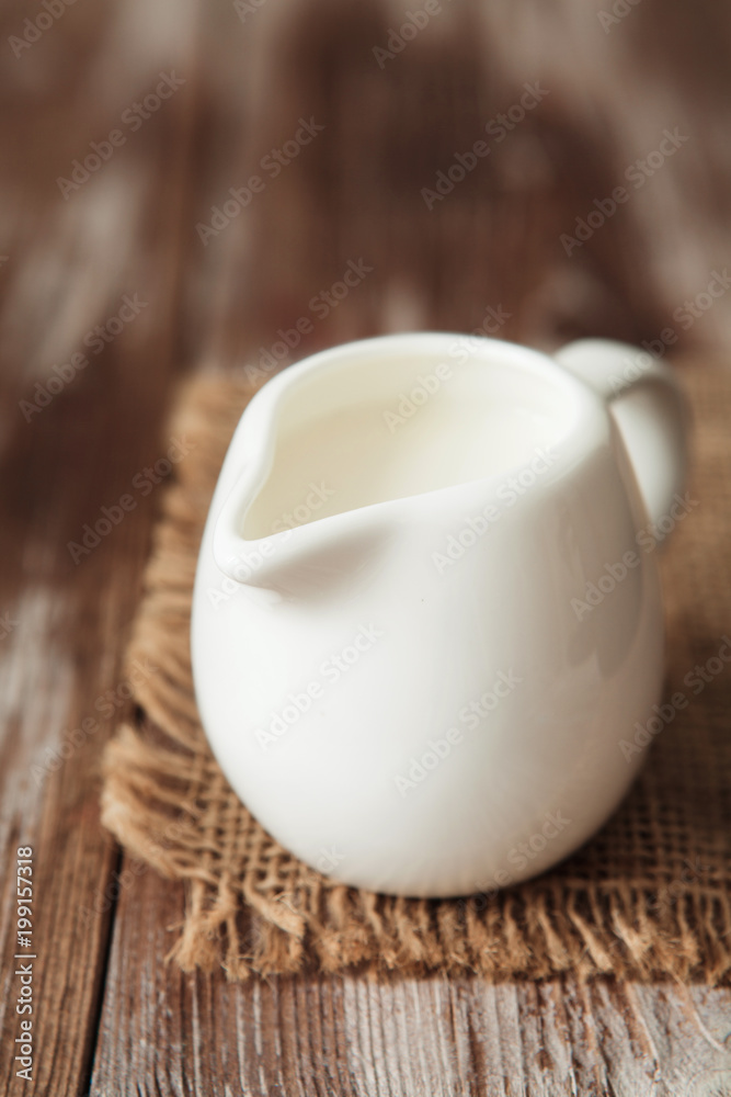 Fresh milk in jug on the wooden table for breakfast Fresh milk in jug on the wooden table for breakfast