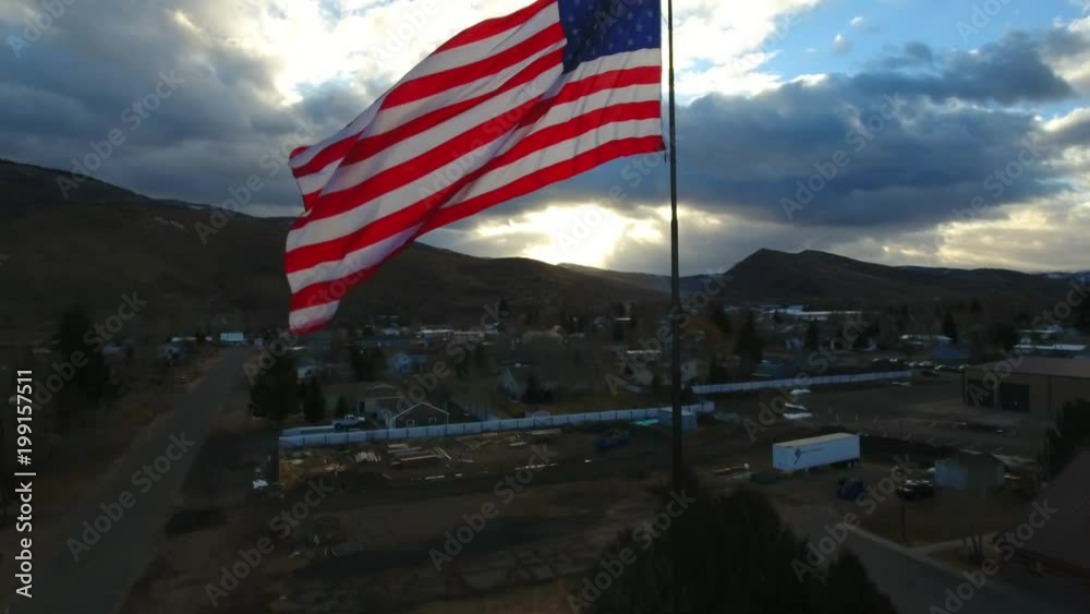 THE FLAG OF THE UNITED STATES OF AMERICA AT SUN RISE ON A CLOUDY DAY